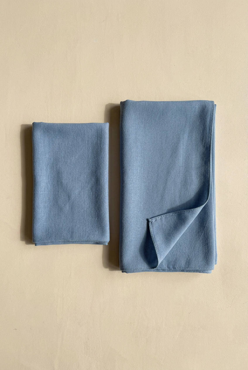 Hijab et bonnet assorti bleus pliés côte à côte sur fond beige