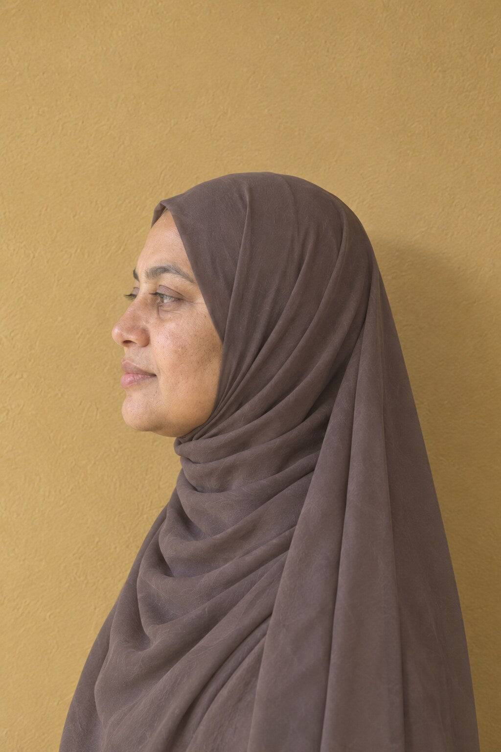 Foulard hijab mousseline vu de profil, drapé autour du visage et sur l'épaule