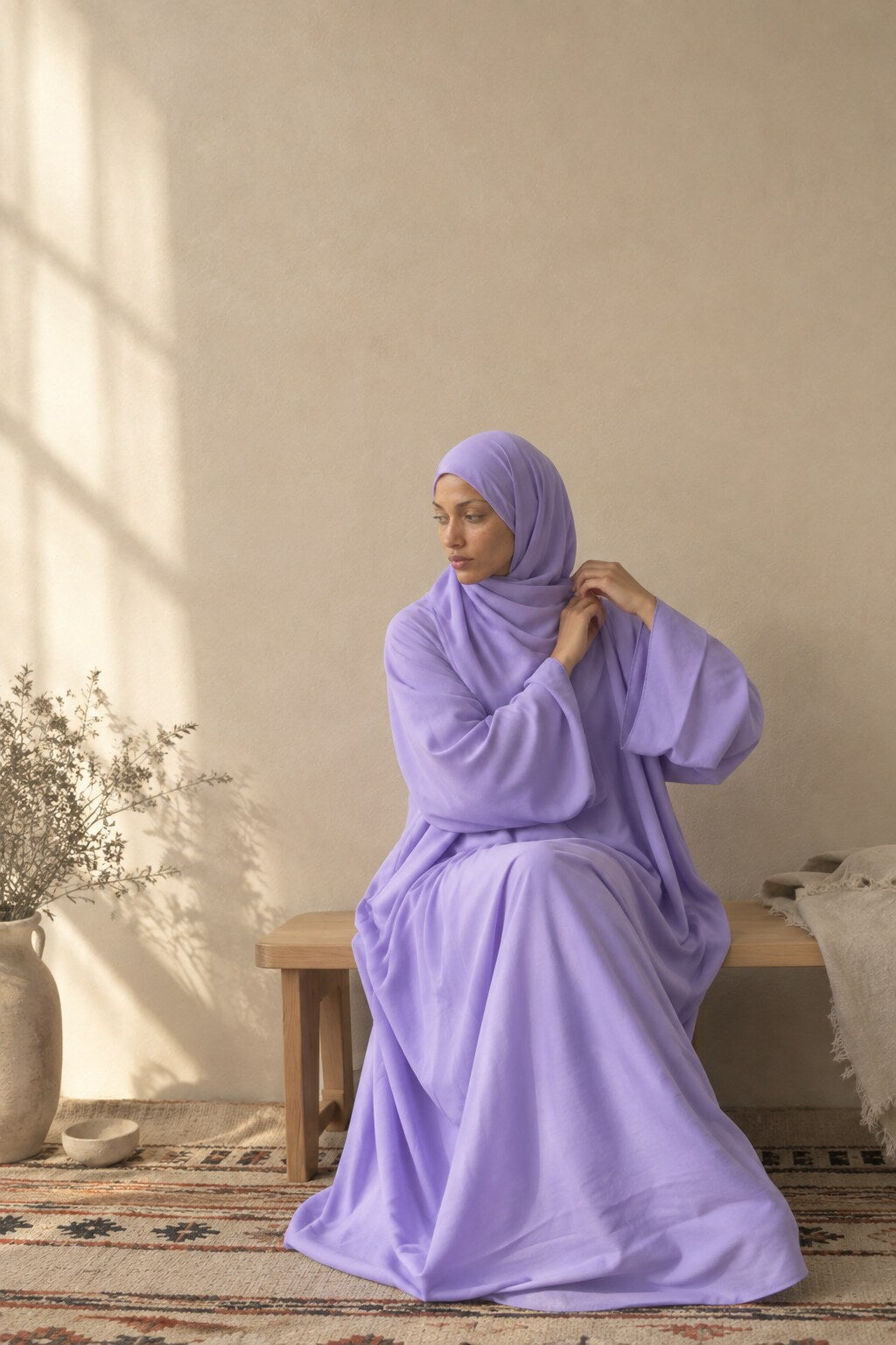 Femme assise sur un banc, en voile mousseline lilas